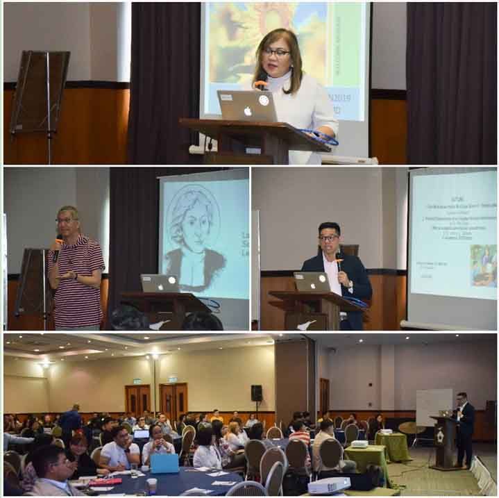 Conference presenters at podiums with slides, and a large audience seated in a hotel ballroom.