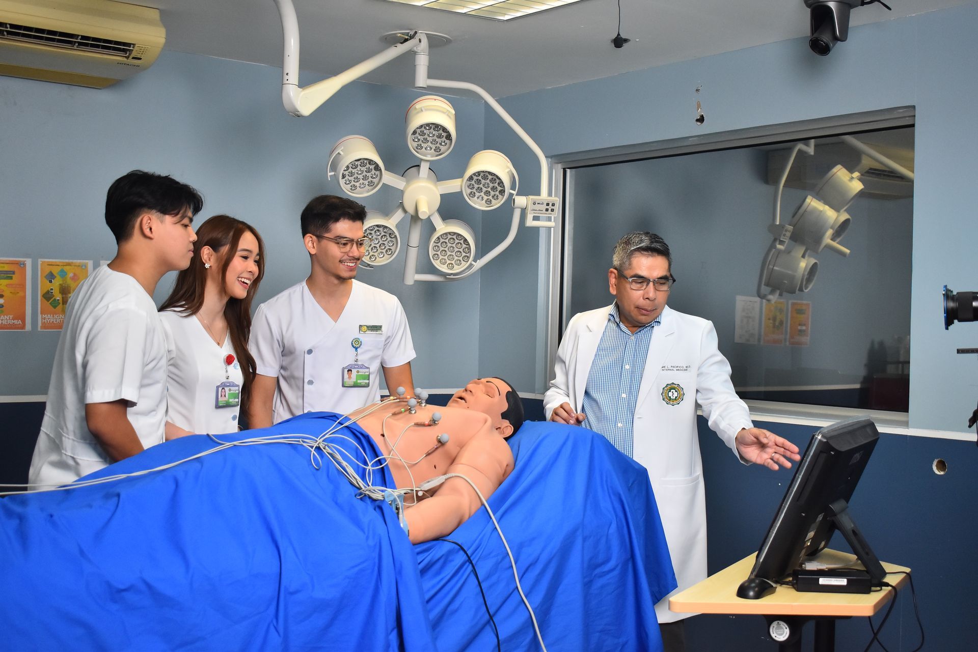 Medical students and instructor around a patient simulator in a training lab