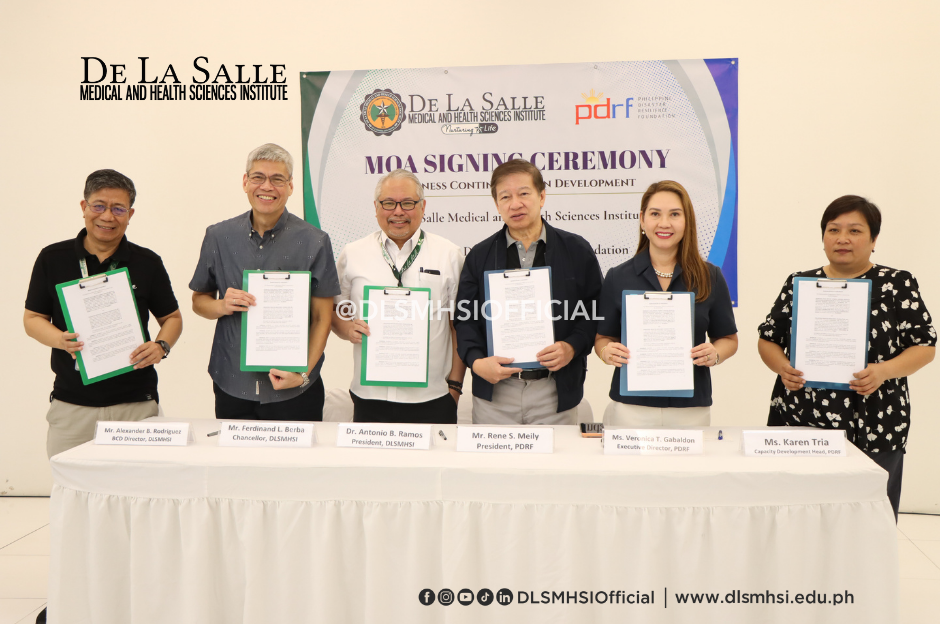 Six people hold certificates at a De La Salle luncheon ceremony behind a white-draped table.