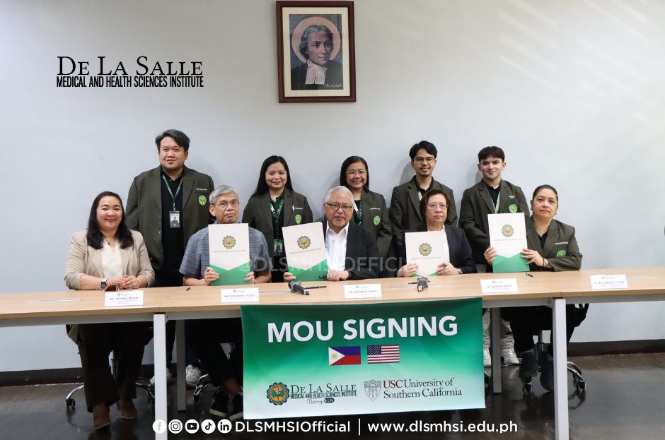 Group of officials at a table during a green “MOU SIGNING” ceremony at De La Salle Medical and Health Sciences Institute