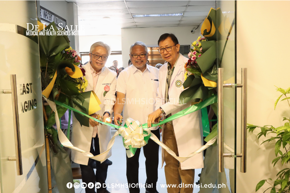 Officials in white coats cut a green ribbon at a doorway during a ceremony