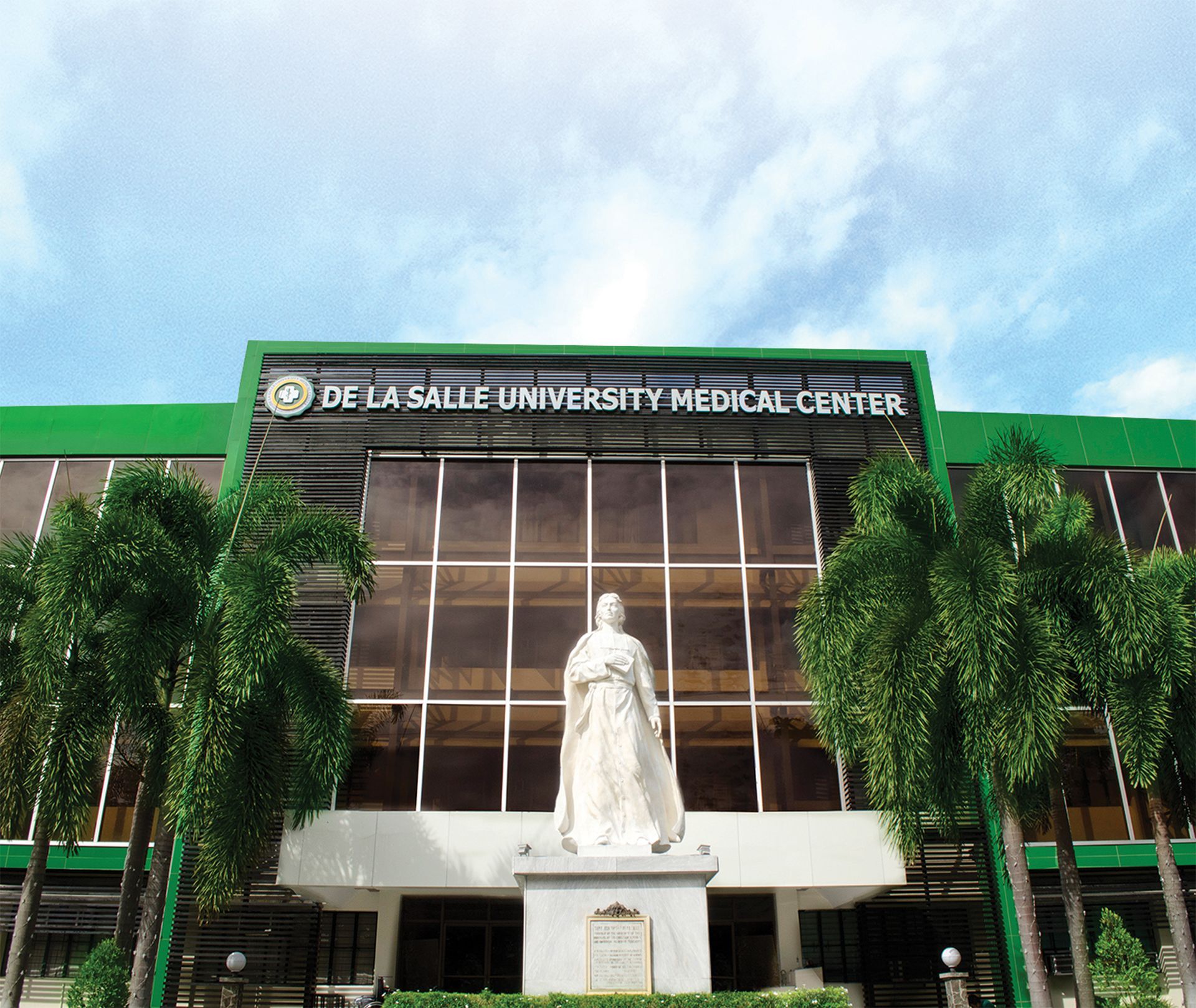 Osaka City University Medical Center building with green façade and a white statue in front