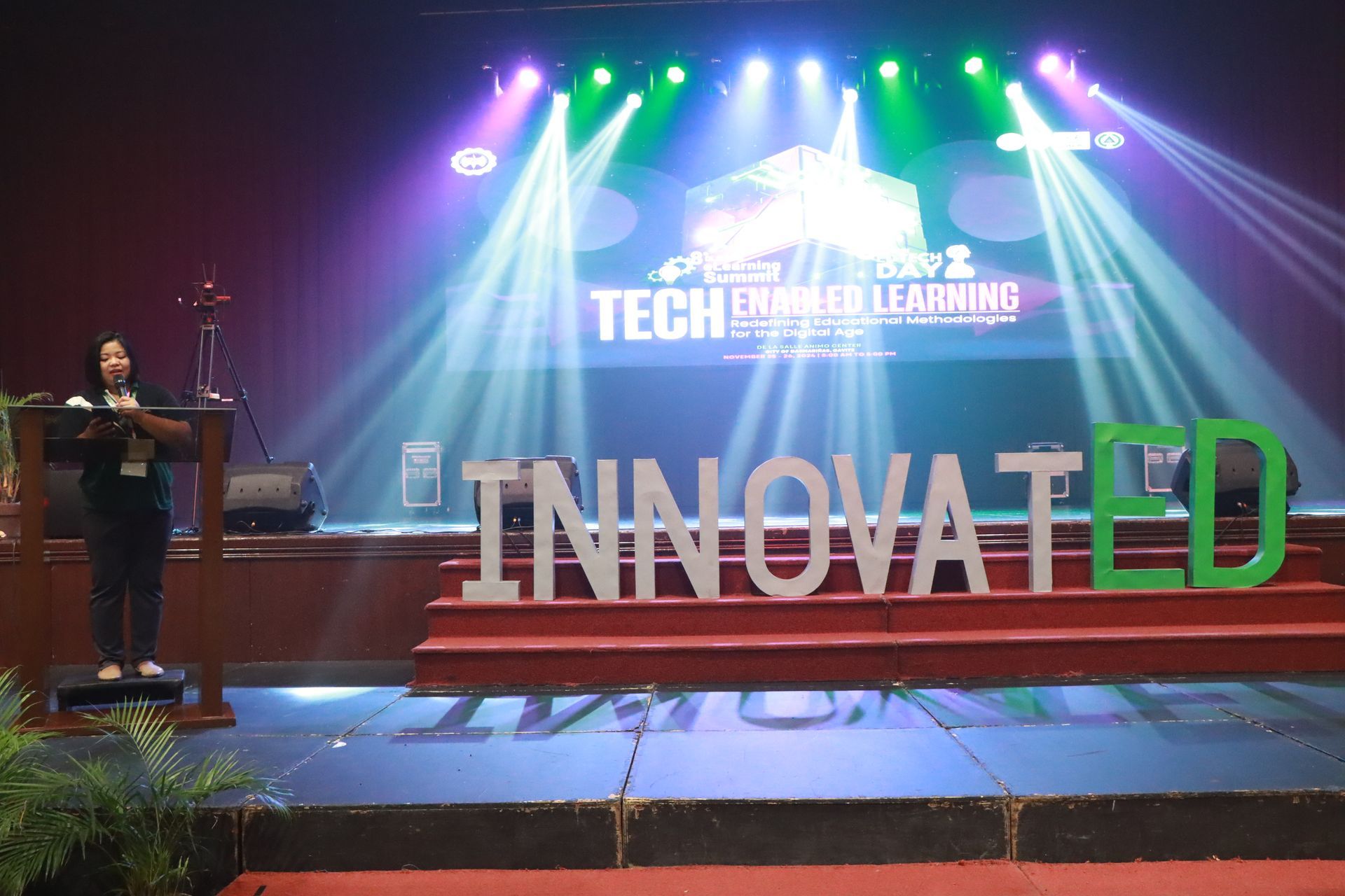 Stage with colorful lights and large “INNOVATED” letters at a tech conference
