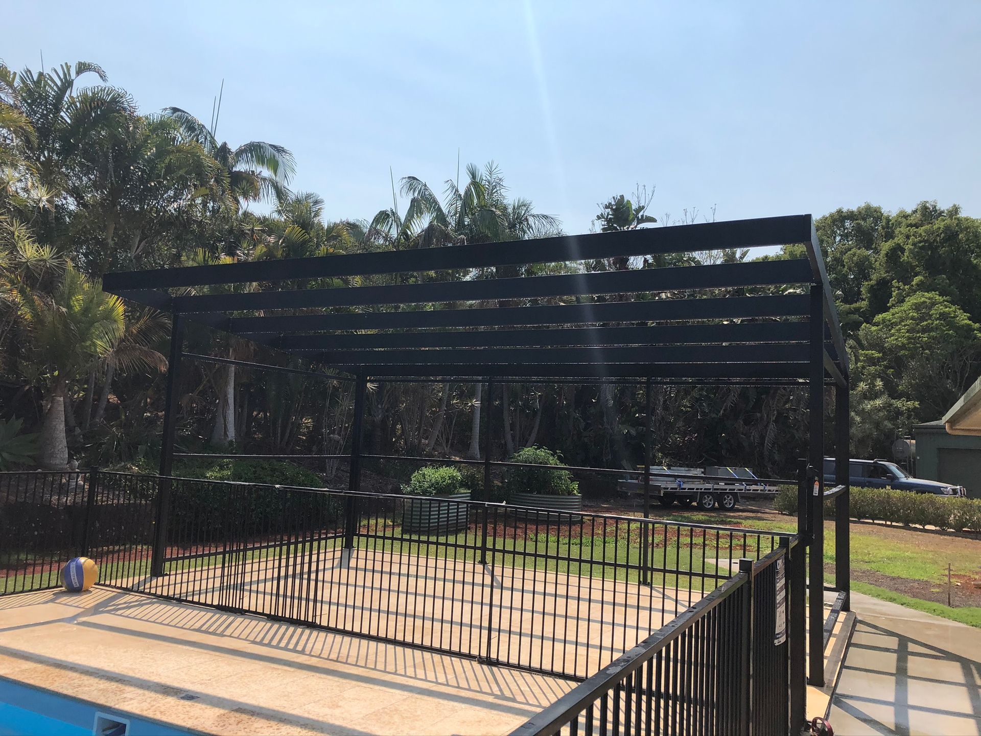 Black Pergola Over A Pool, Fenced With A Black Decorative Barrier — Soward Steel & Aluminium Fabrication in Lismore, NSW