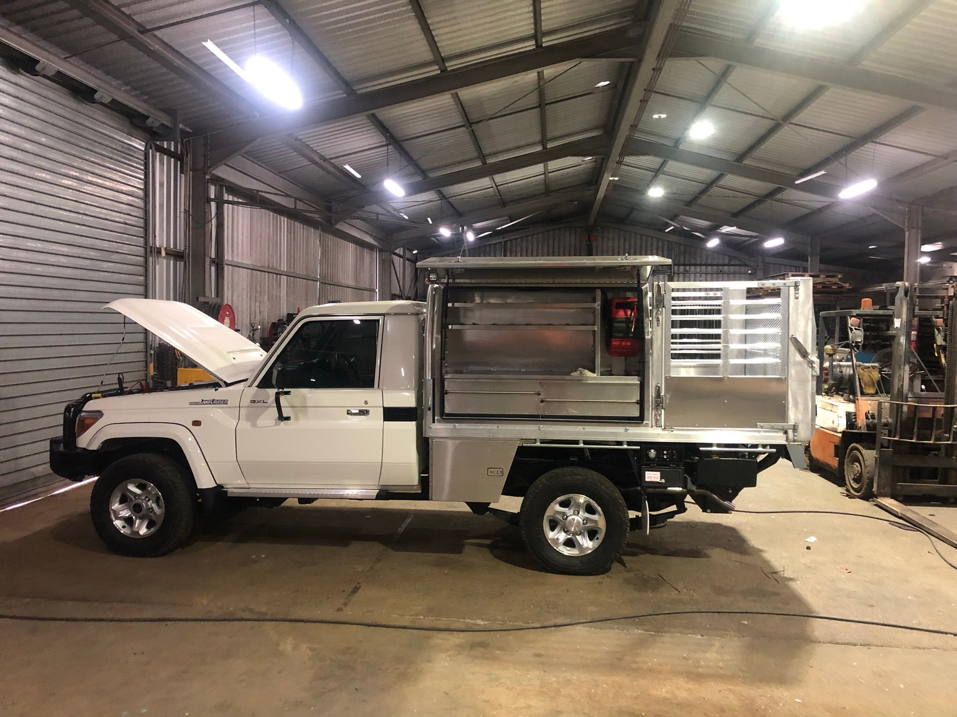 White Pickup Truck With Custom Aluminum Utility Bed Inside A Workshop — Soward Steel & Aluminium Fabrication in Kyogle, NSW