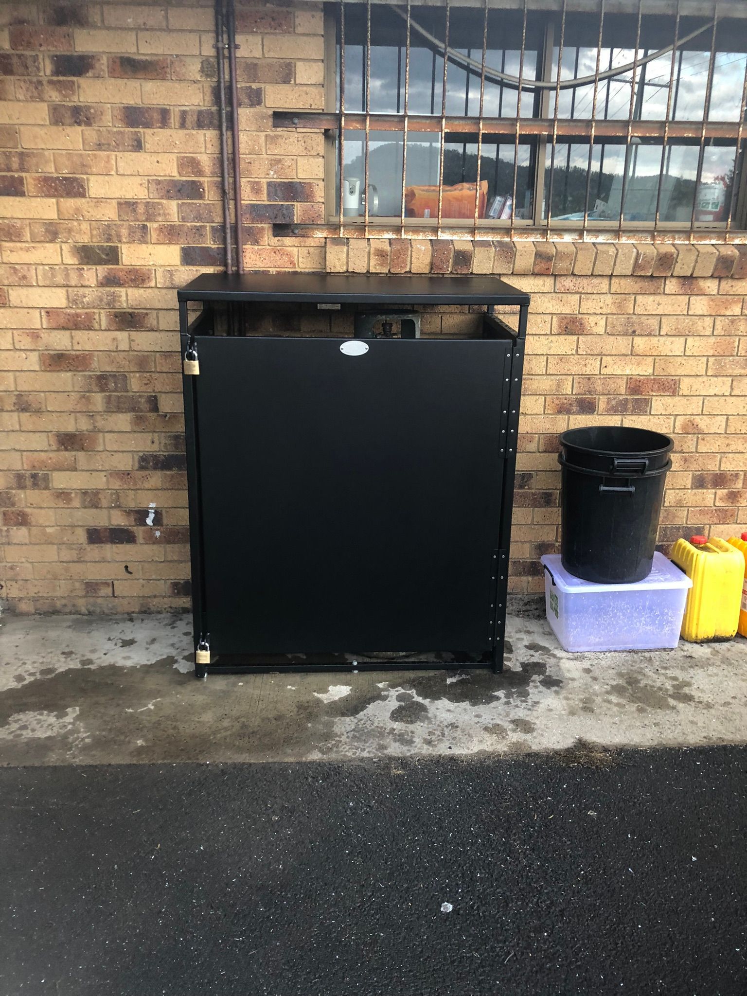 Black Metal Cabinet Against A Brick Wall — Soward Steel & Aluminium Fabrication in Lismore, NSW
