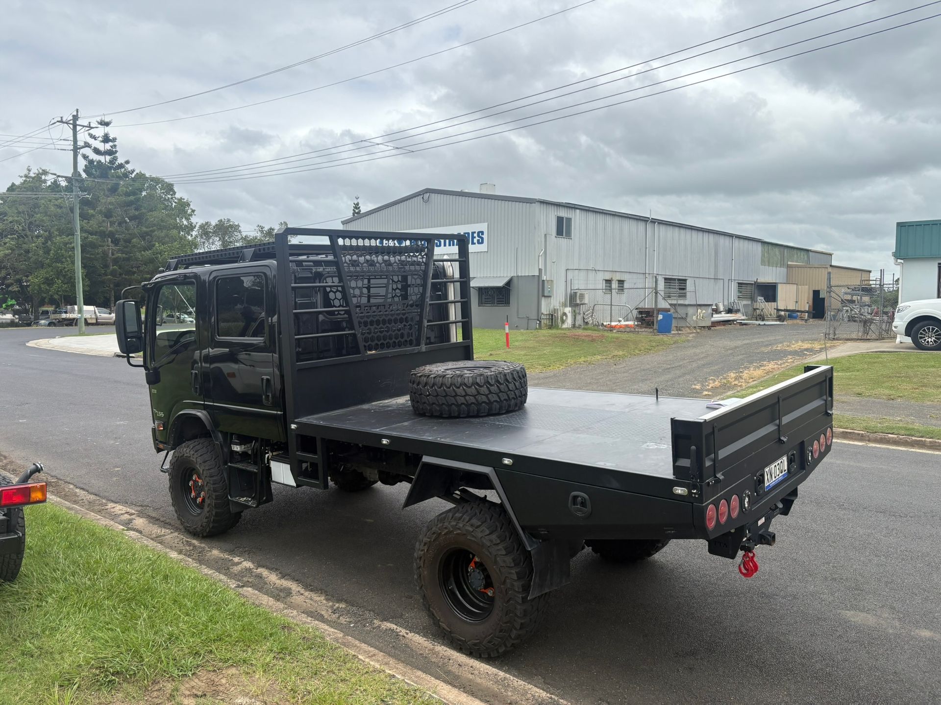 Black Flatbed Truck With Large Tires Parked On A Street — Soward Steel & Aluminium Fabrication in South Lismore, NSW