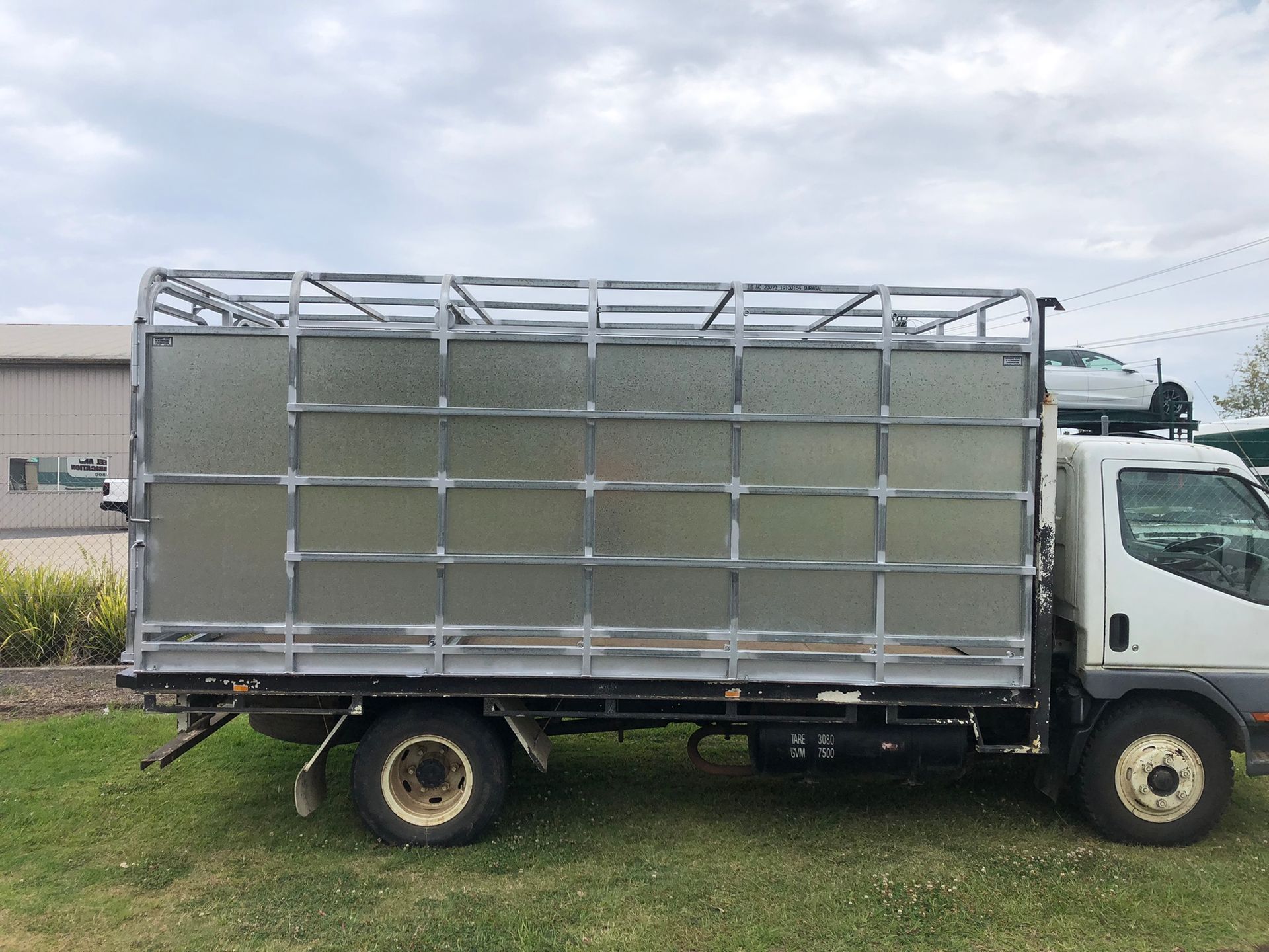 White Truck With Caged Sides Parked On Grass — Soward Steel & Aluminium Fabrication in Lismore, NSW