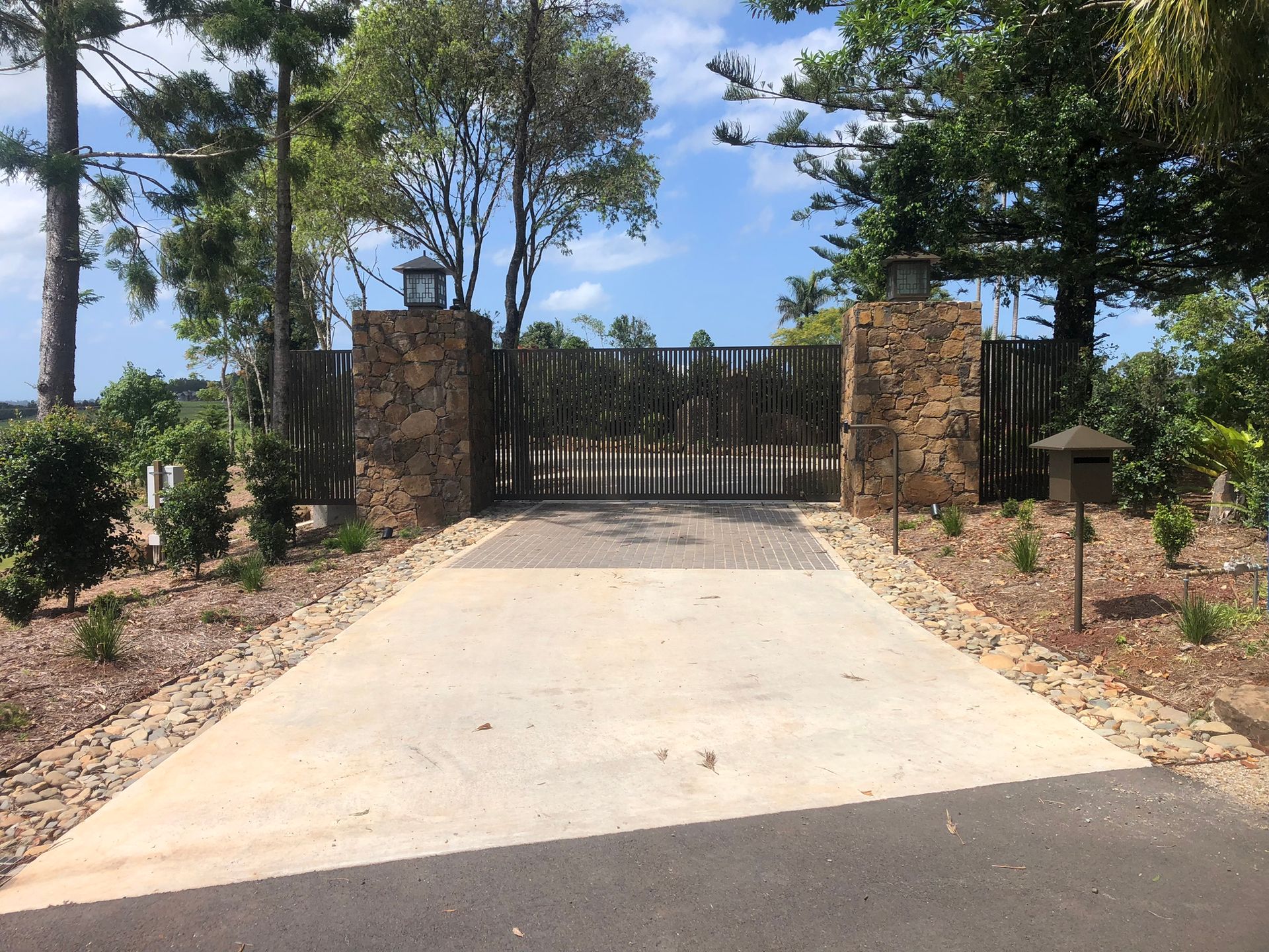 Driveway Leading To Gated Entrance With Stone Pillars And Trees — Soward Steel & Aluminium Fabrication in Kyogle, NSW