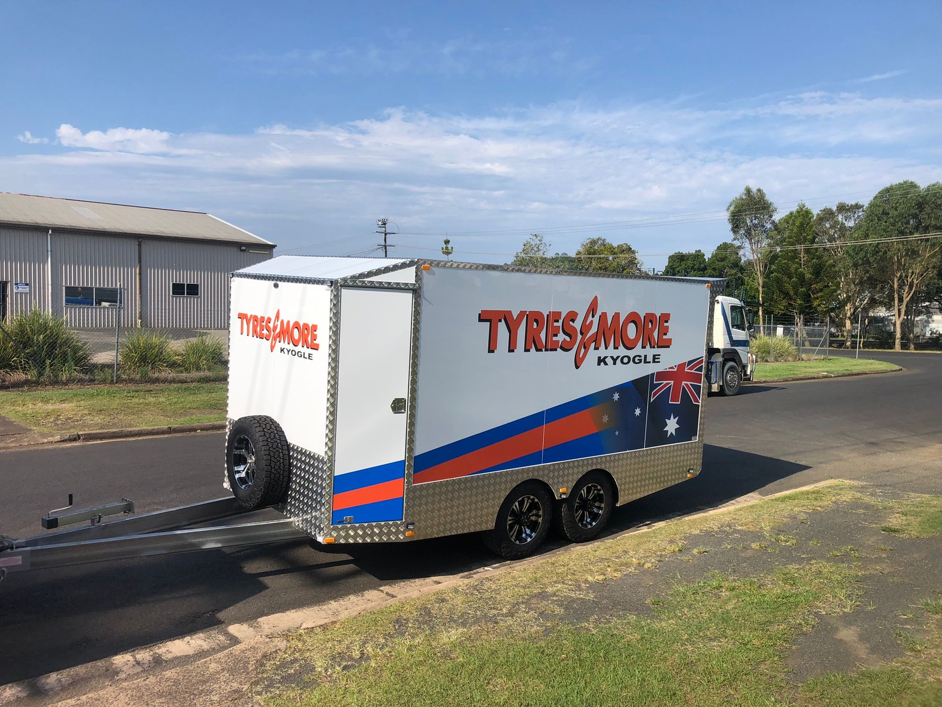 Aluminum Trailer With Ramps Parked Outside a Metal Building — Soward Steel & Aluminium Fabrication in South Lismore, NSW