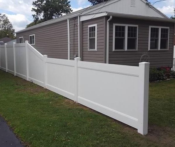 a white picket fence with a blue sky in the background