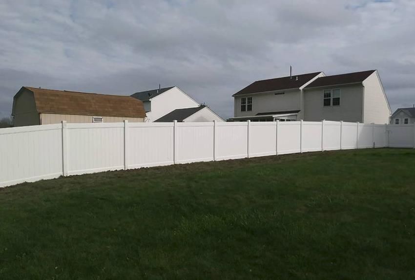 a white picket fence surrounds a lush green yard