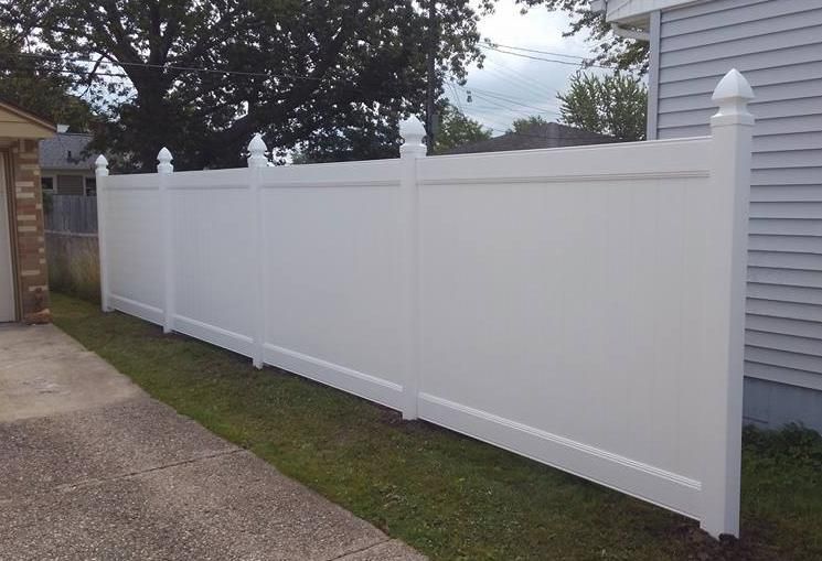 a white picket fence surrounds a lush green yard