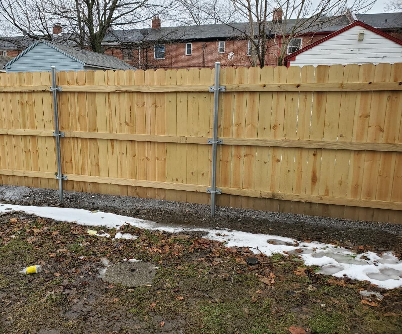 Charming wooden fence encircling a house, set against a lush green lawn.
