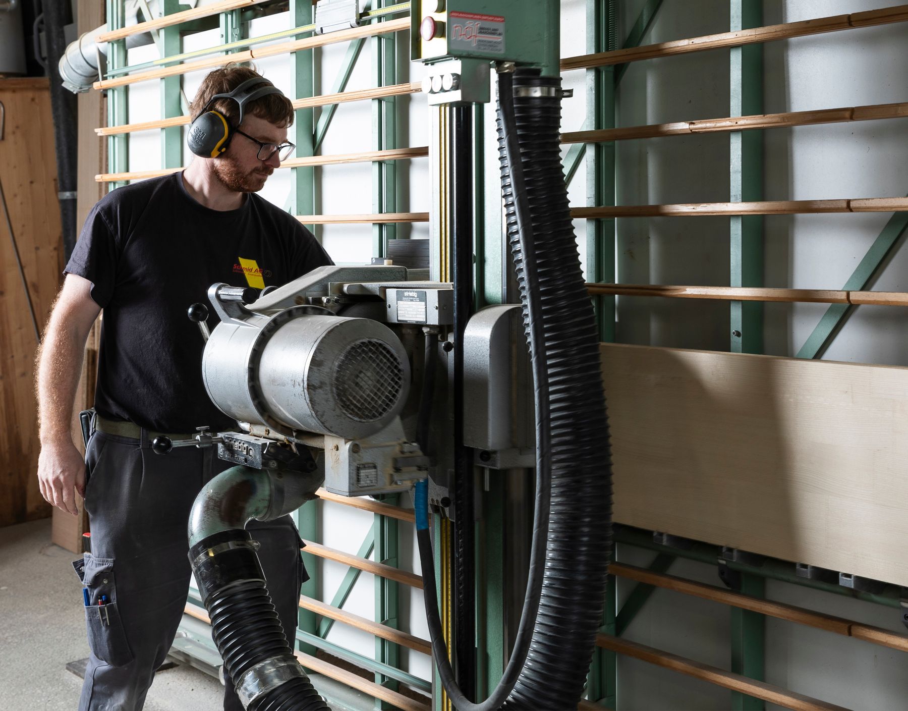 Ein Mann mit Kopfhörern arbeitet an einer Maschine
