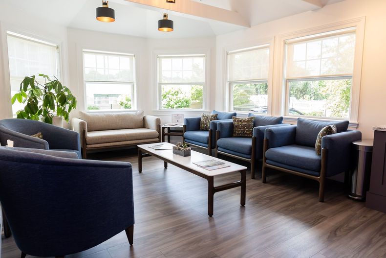 Bright reception lounge with bay windows and comfortable seating at Mann Family Dental in Manchester, NH