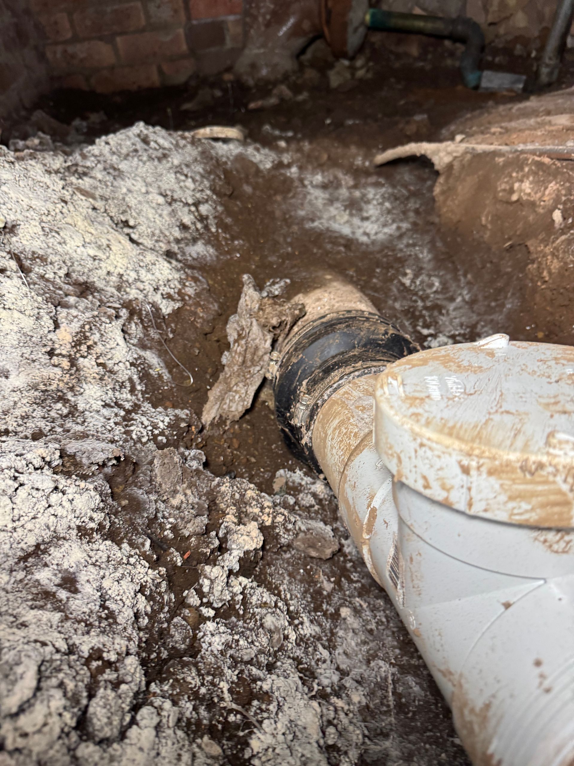 Basement with white powdery substance, exposed plumbing, and dirt  — Fair Plumbing In Shellharbour, NSW