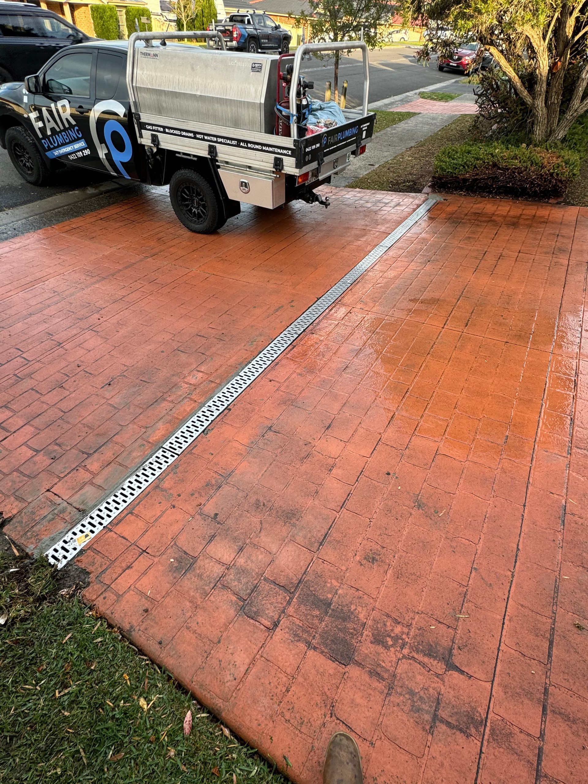 Truck parked on red brick driveway with linear drain installed — Fair Plumbing In Shellharbour, NSW