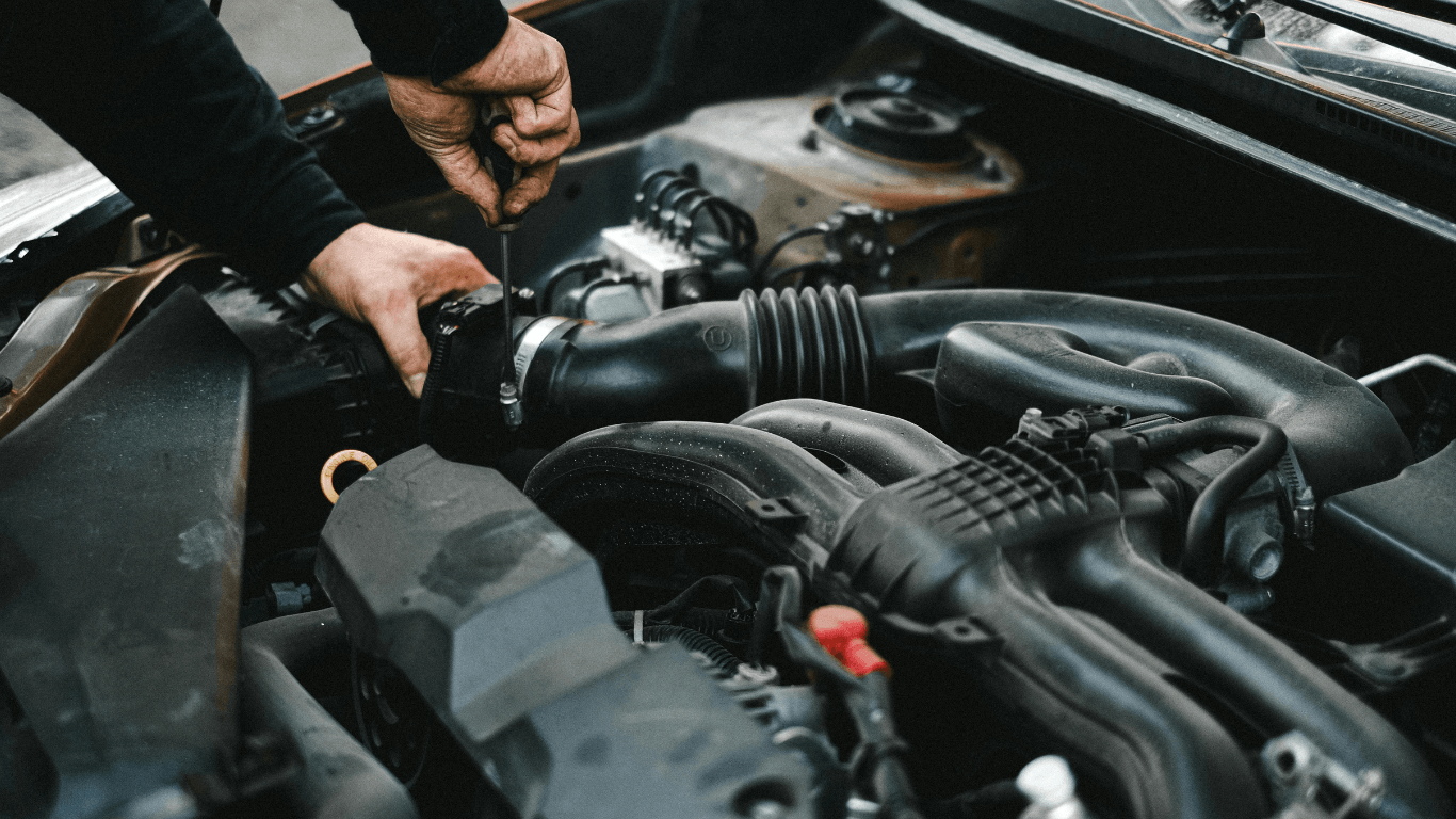 a woman leaning on her broke down car calling a mechanic