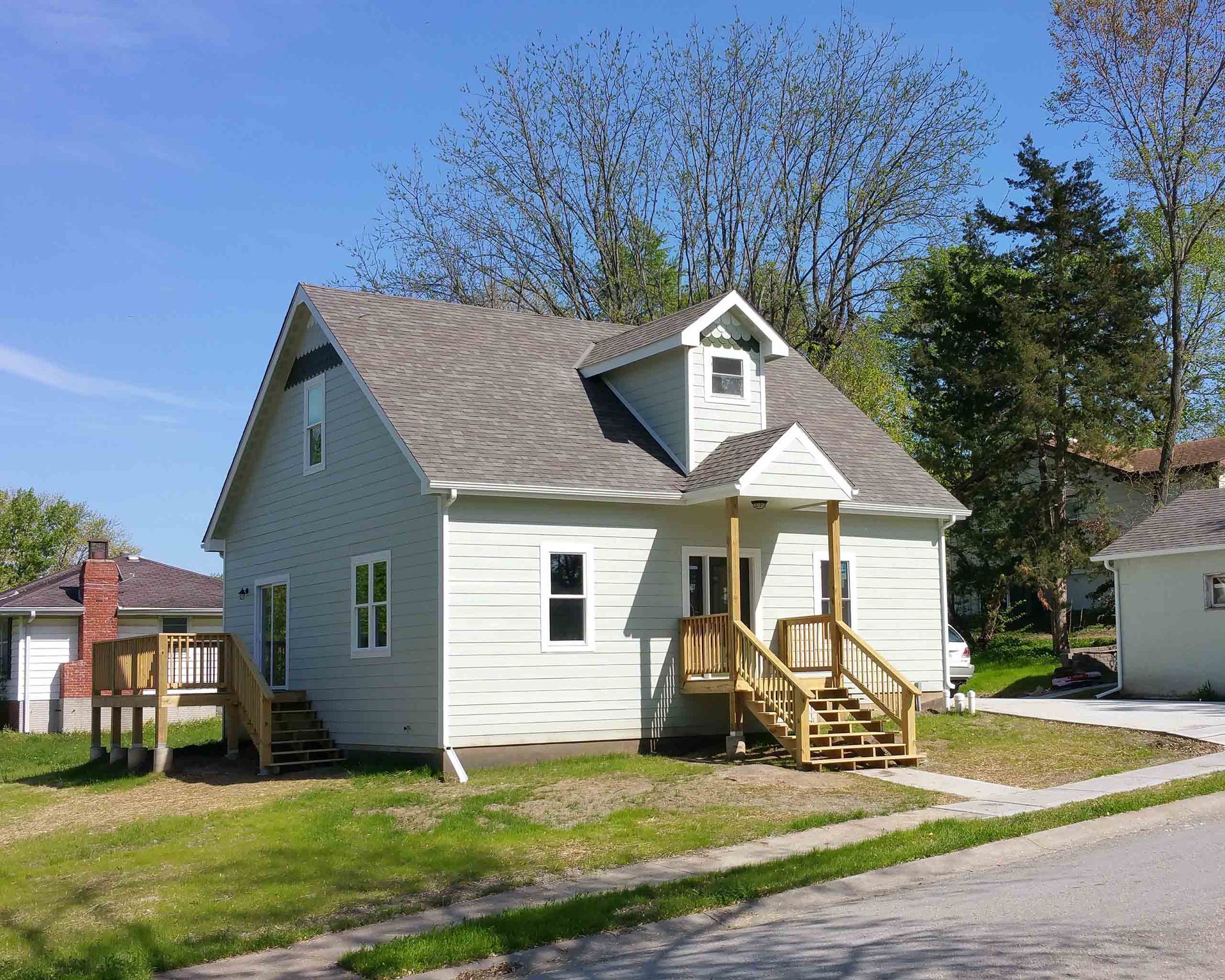 A small white house with a porch and stairs