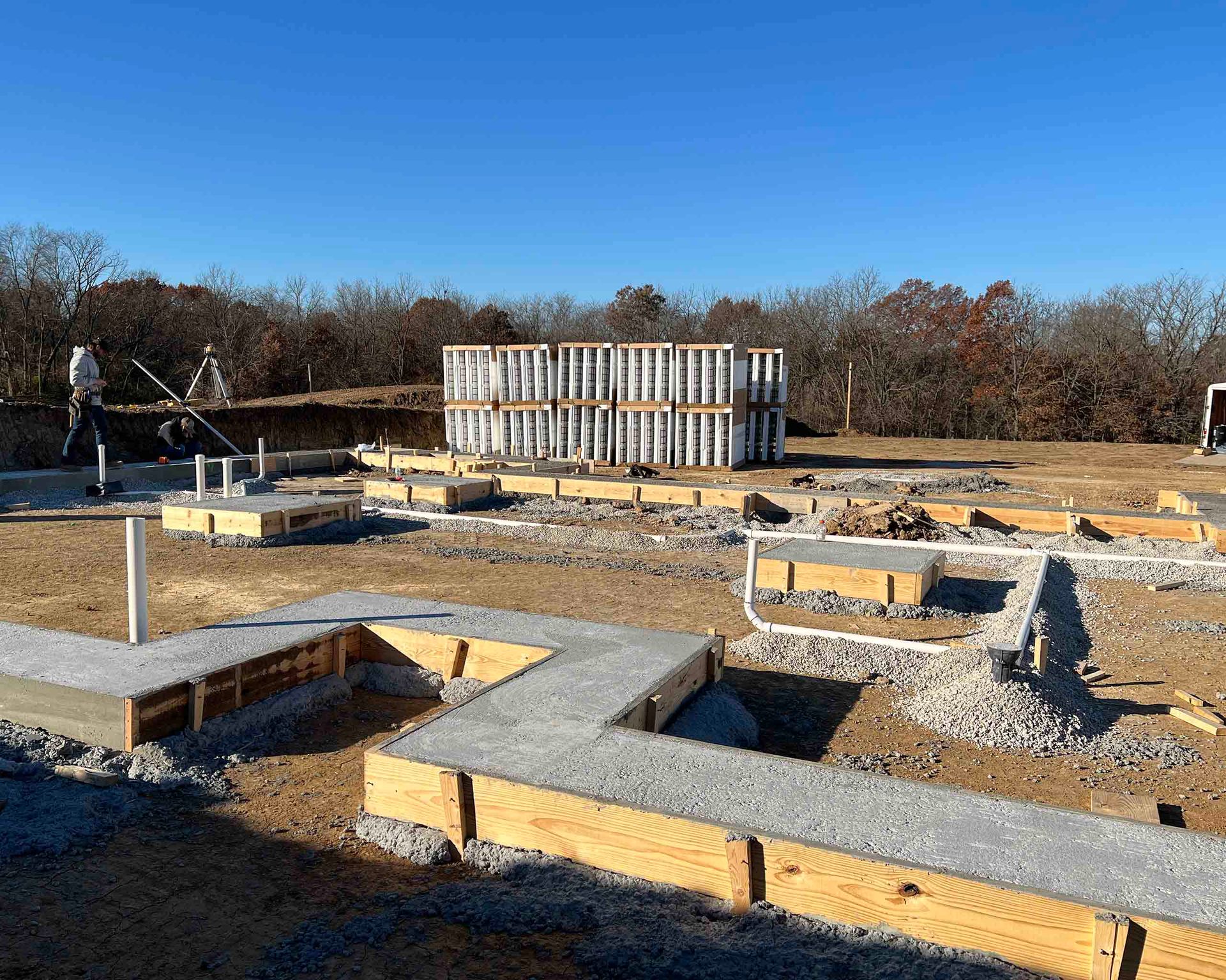 A building is being built in a field with a blue sky in the background.