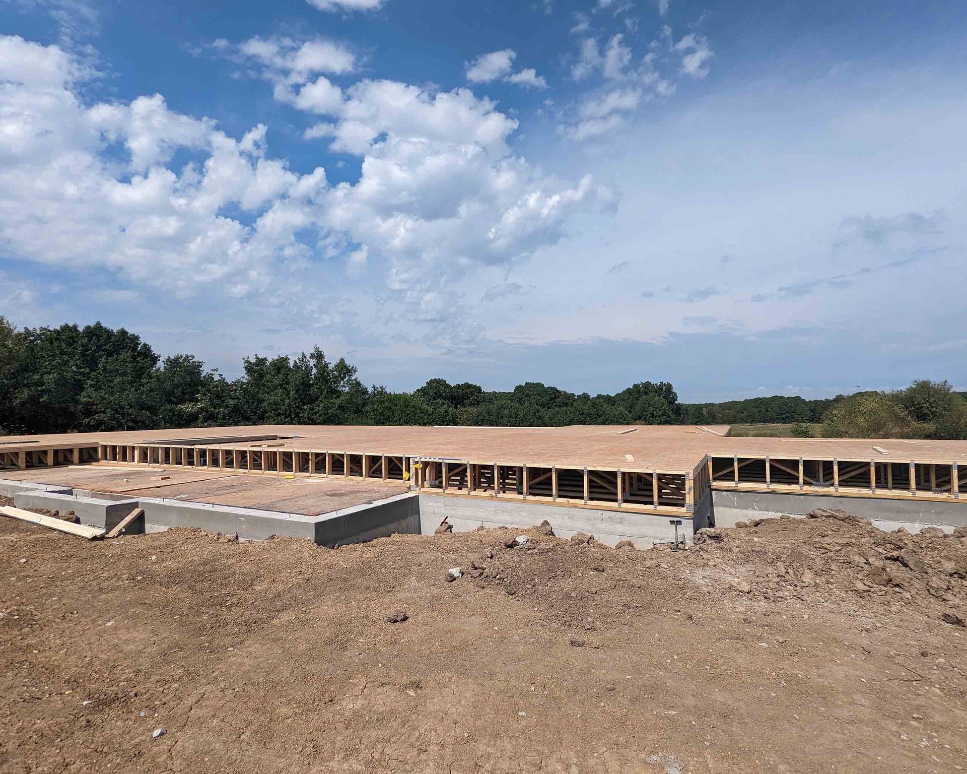 A house is being built in the middle of a dirt field.