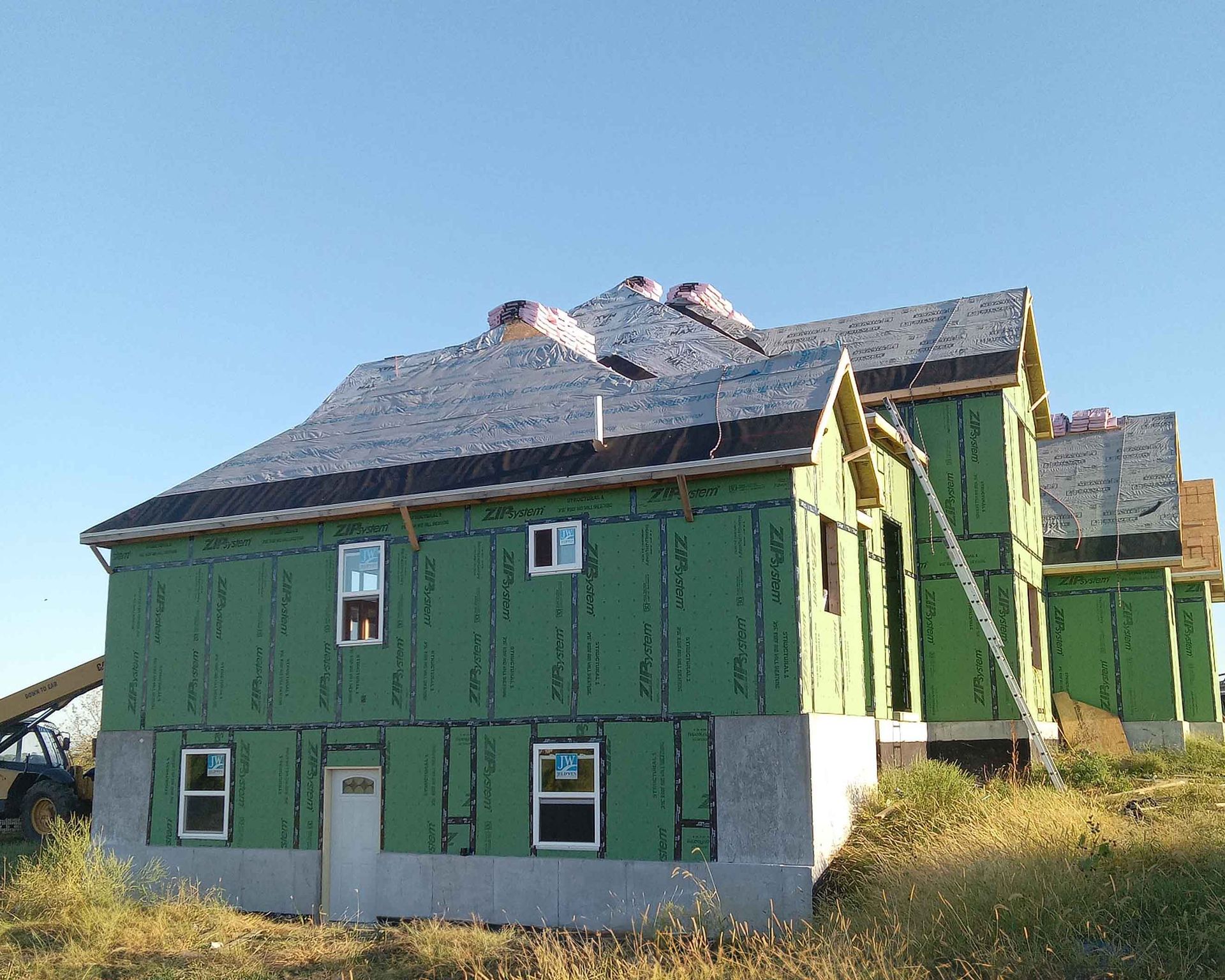 A house that is being built with green siding