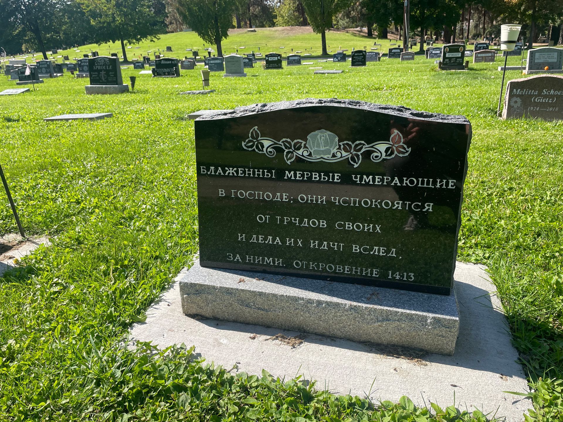 A gravestone in a cemetery with russian writing on it