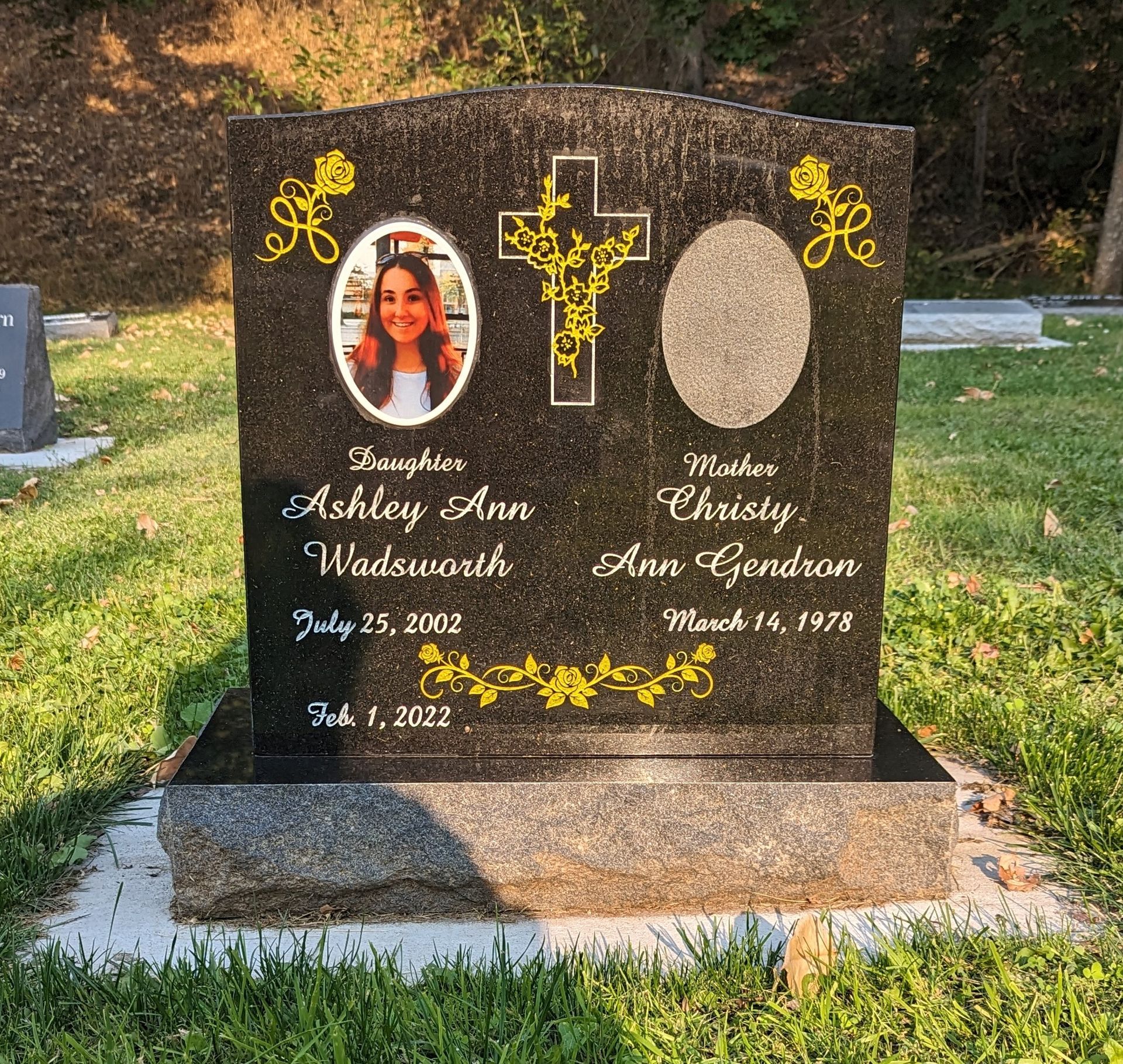A black gravestone with a picture of a girl on it