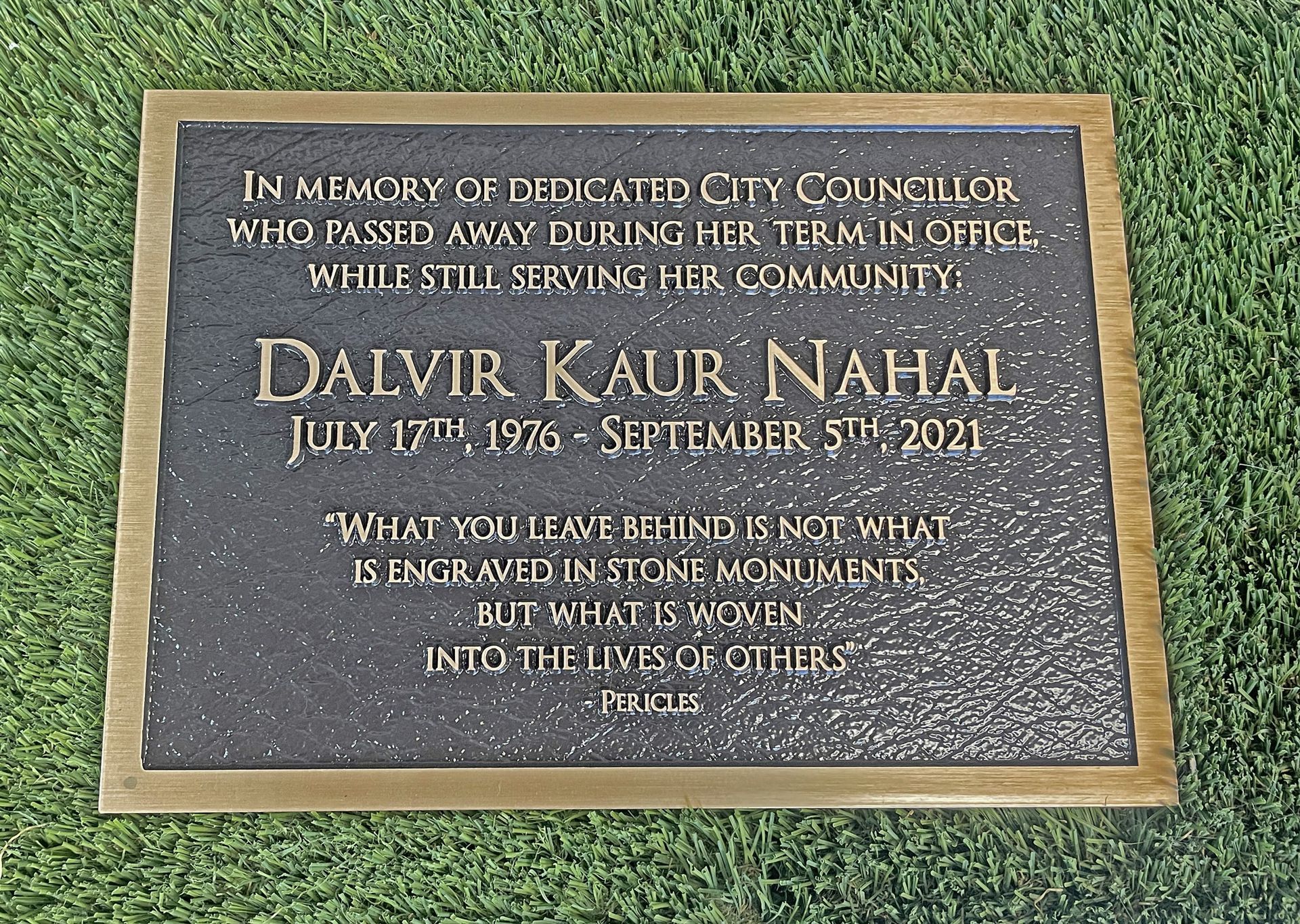 A plaque for dalvir kaur nahal is on the grass