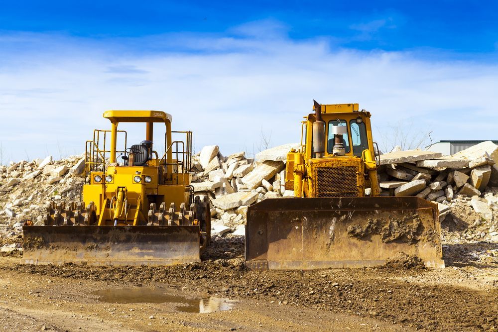 Two Yellow Bulldozers Clearing Debris at a Demolition Site Under a Blue Sky — Lifters Hire in Cambridge, TAS