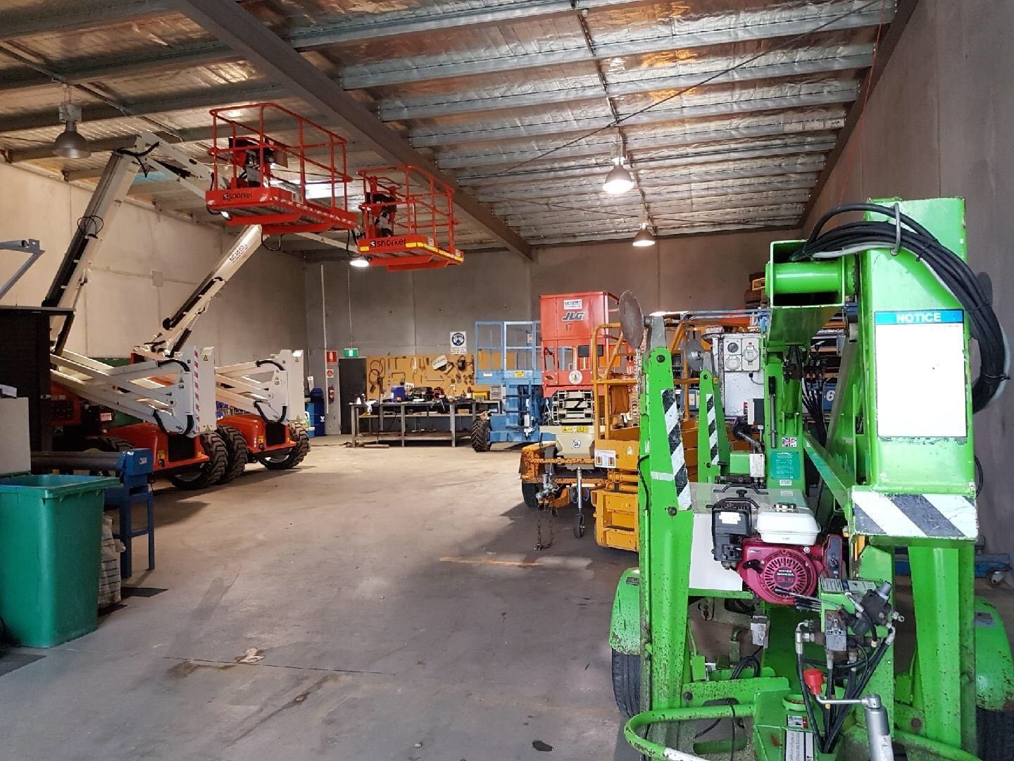 Large Warehouse Workshop With Machinery, Tools, and a Green Lift in the Foreground — Lifters Hire in Cambridge, TAS