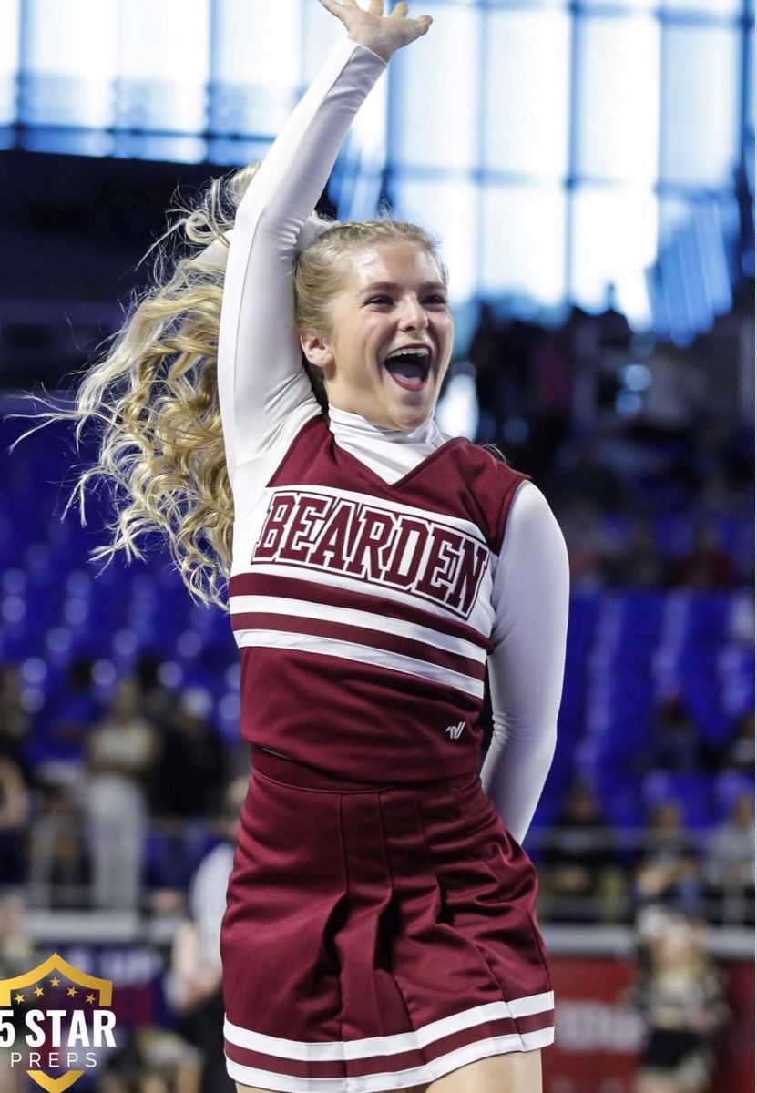 A cheerleader wearing a maroon and white uniform with the word bearden on it