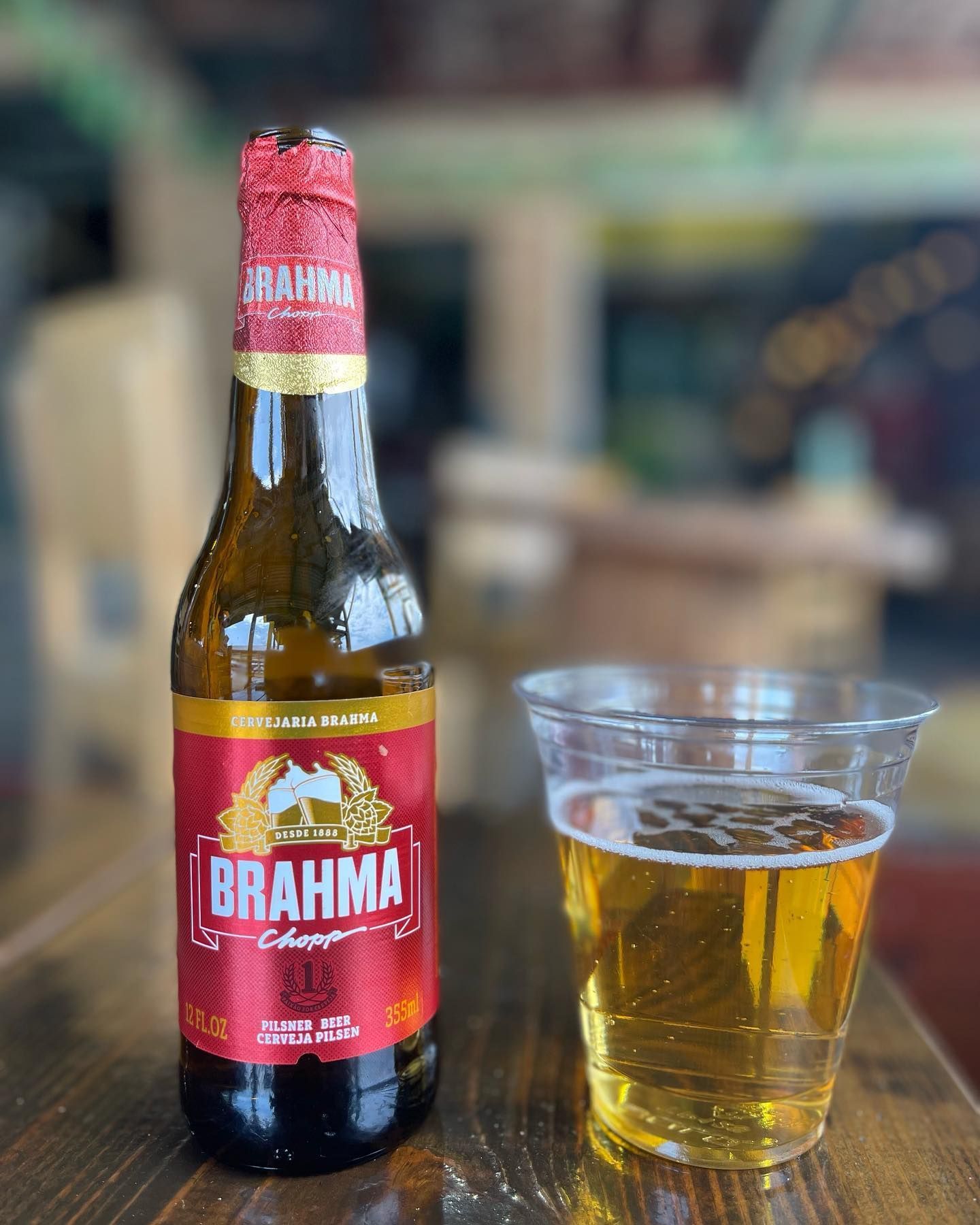 A beer bottle with a full glass of beer next to it