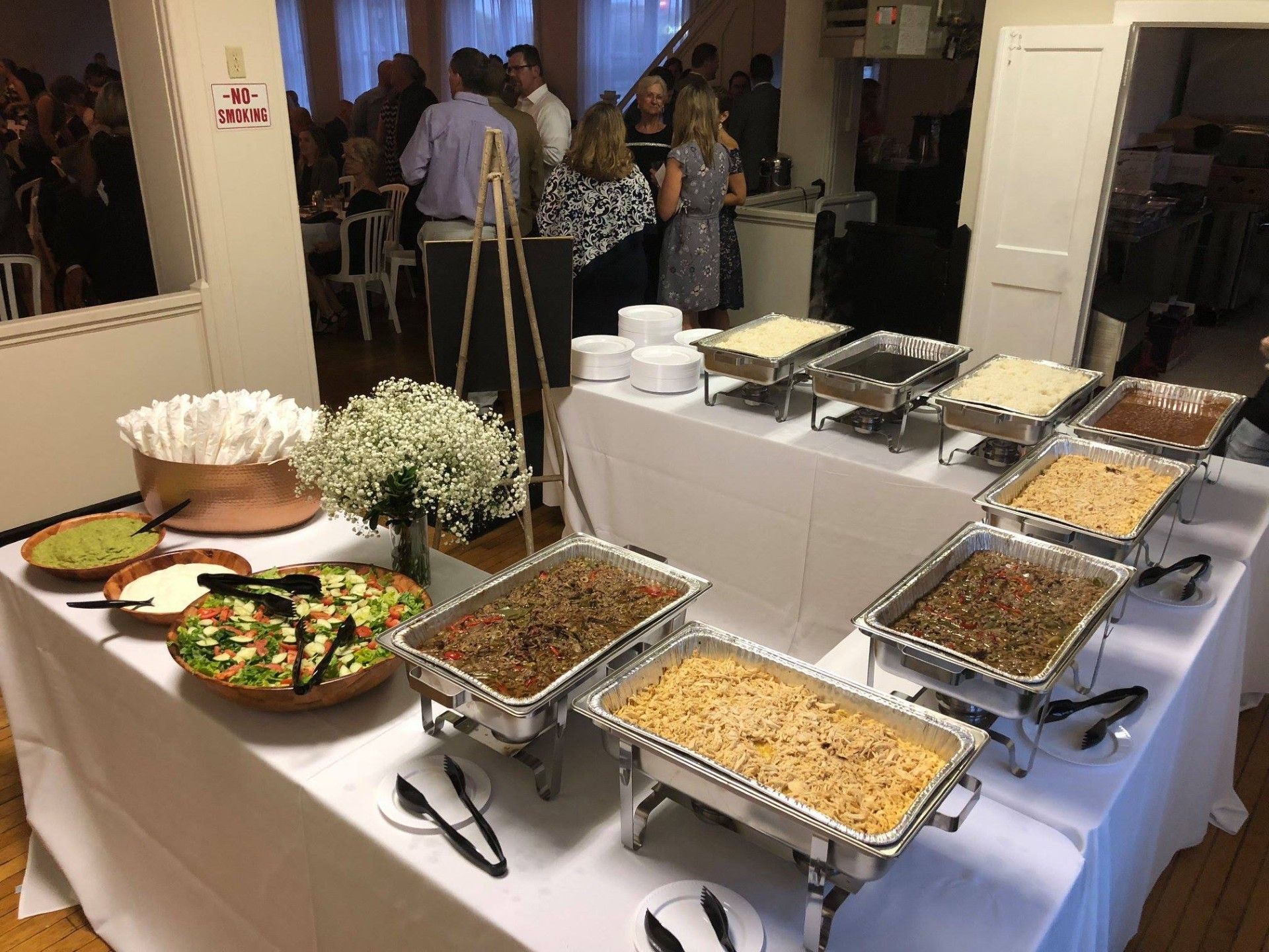 There are many trays of food on the table.