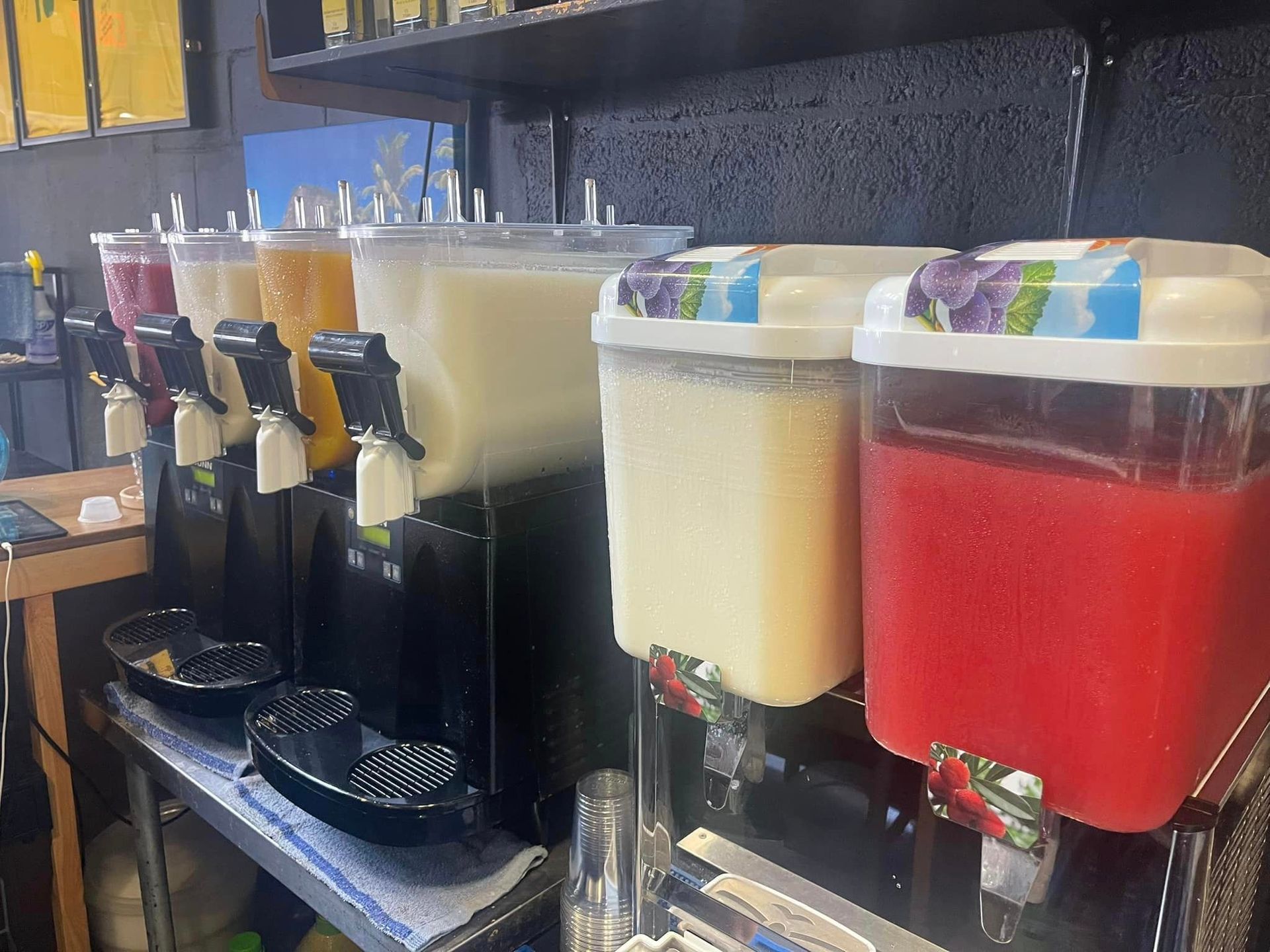 A row of beverage dispensers filled with different types of beverages.