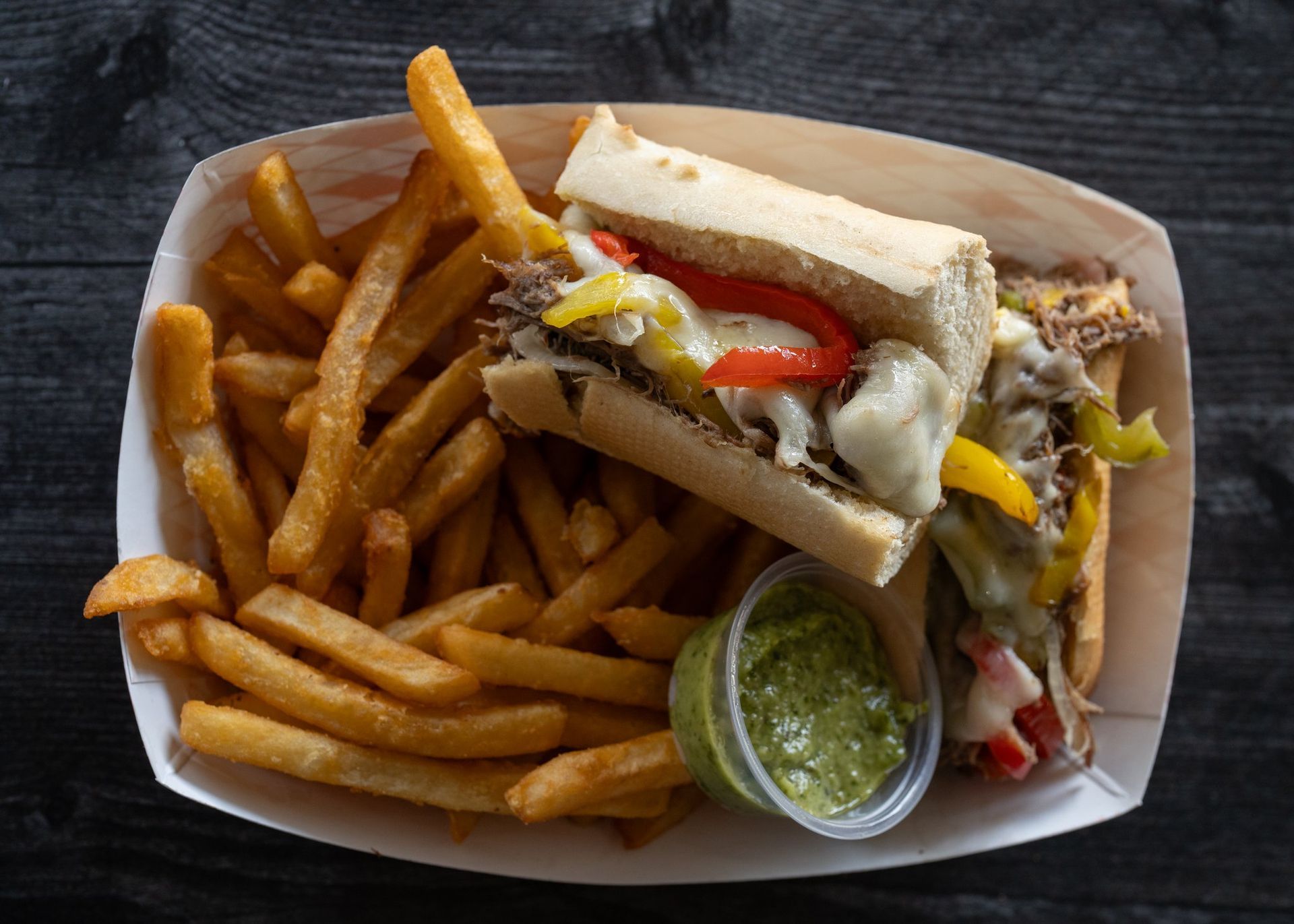 A paper plate topped with a sandwich and french fries.