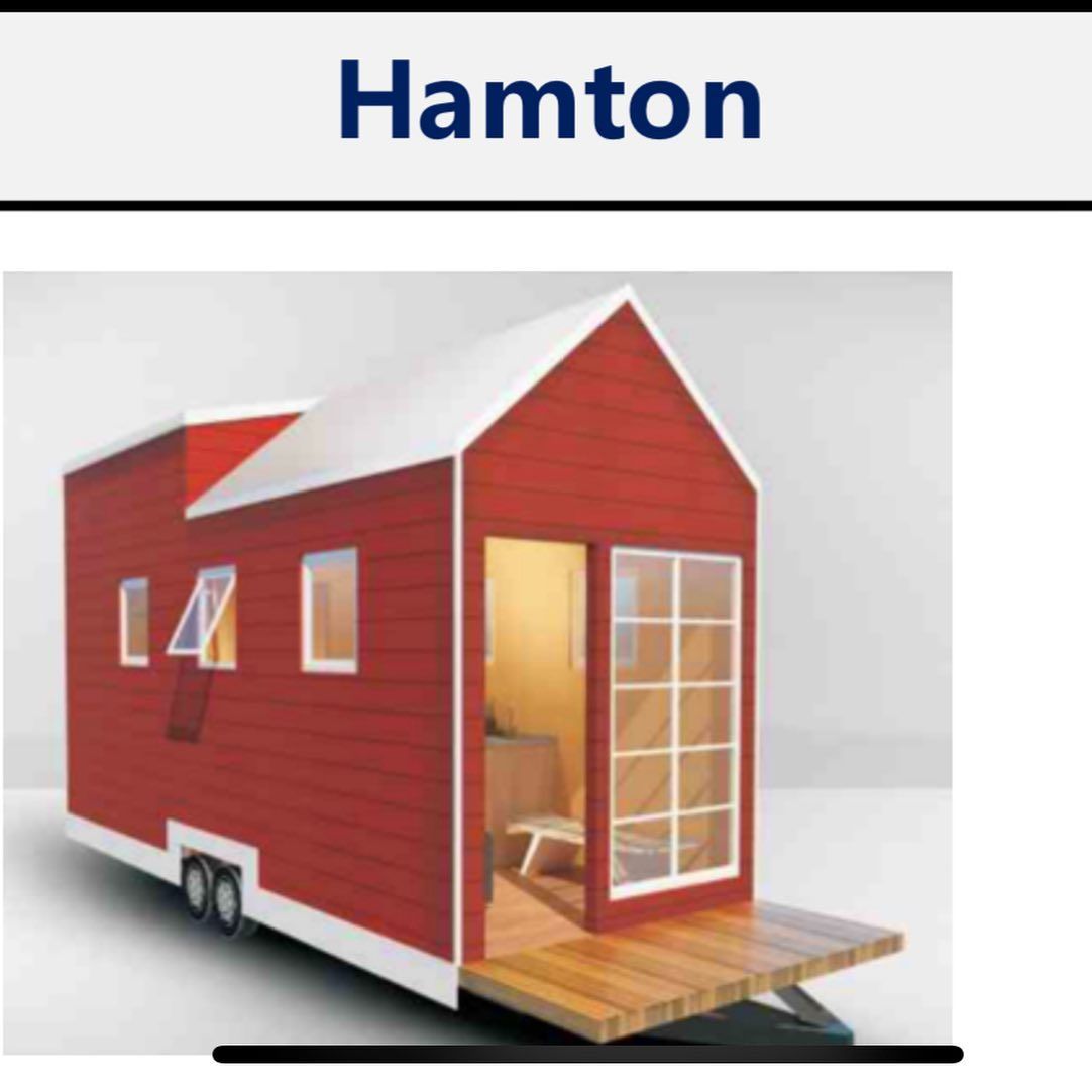Red tiny house on wheels with white trim and open door leading to an interior.