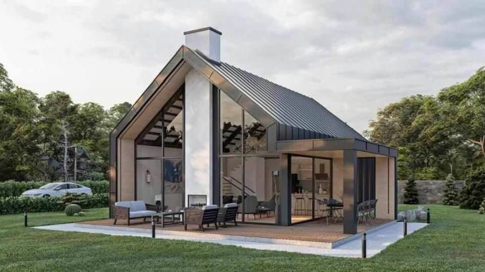 Modern house with glass front, sloped roof, and outdoor seating on a patio.