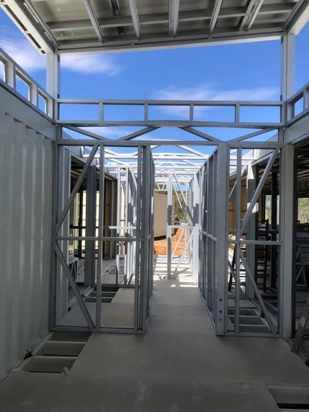 Interior view of a building under construction, showing metal framing and exposed beams.