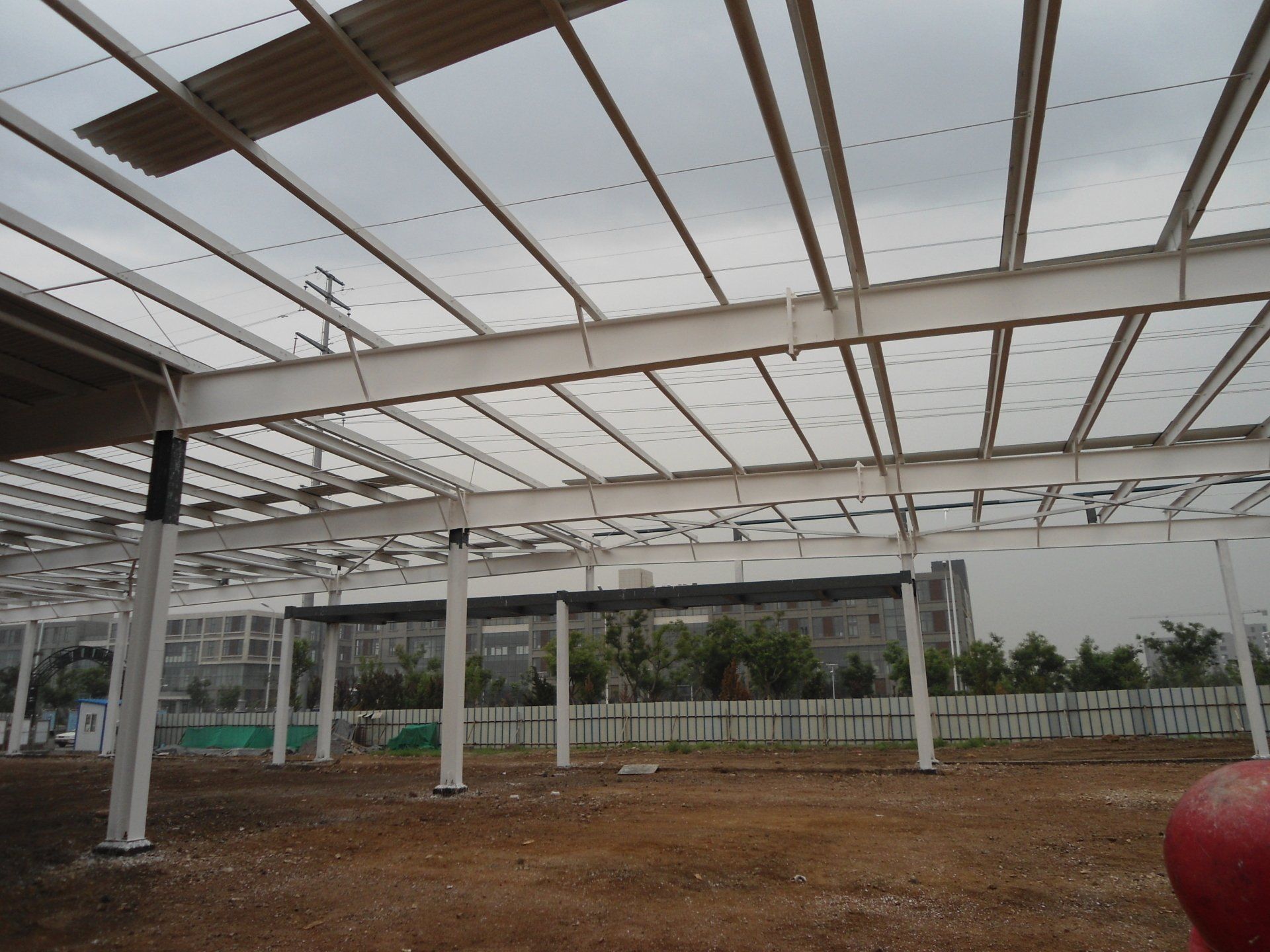 Steel framework of a building under construction, with translucent roofing.
