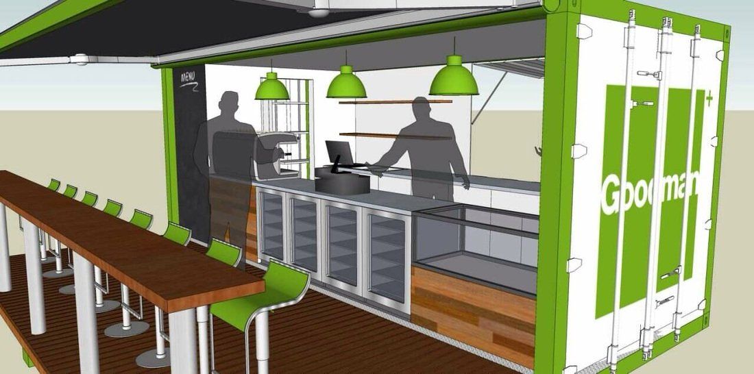A green and white shipping container transformed into a bar. Two figures behind the bar, with seating in the foreground.