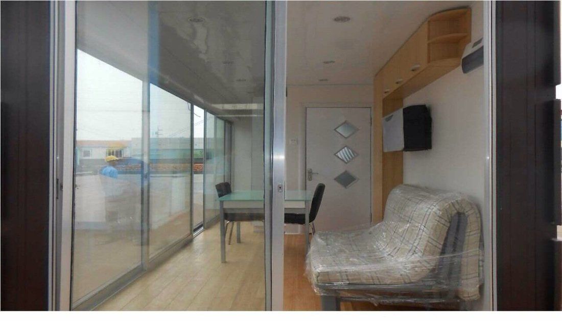 Interior view: room with sliding glass doors, a small sofa, desk, and cabinets.