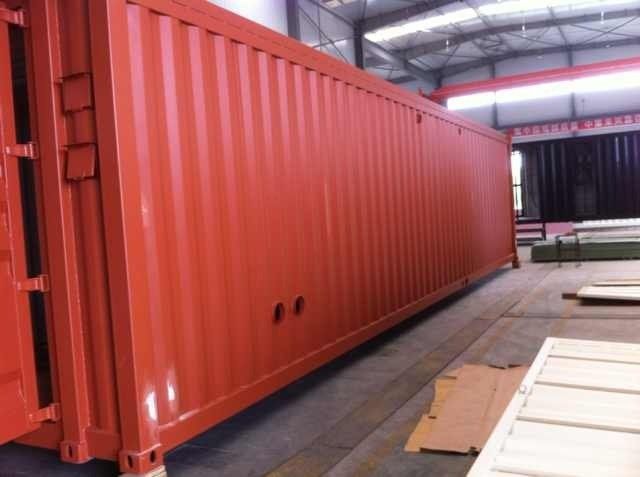 Red shipping container in a factory setting.