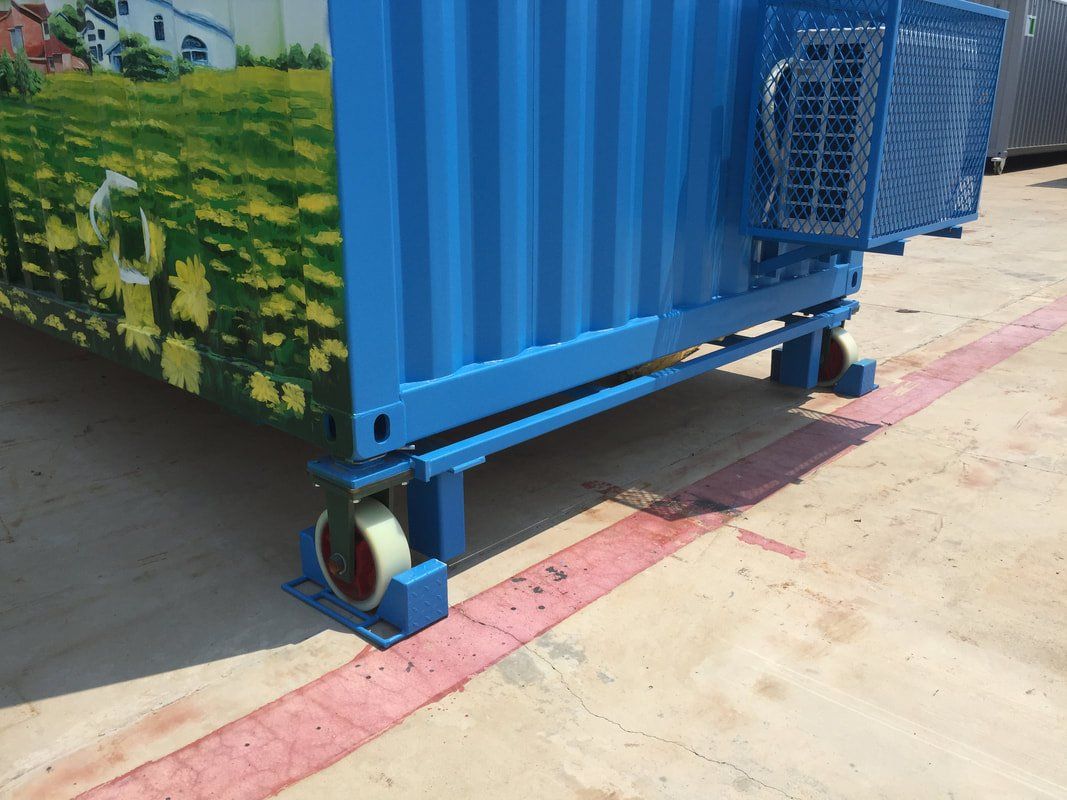 Blue shipping container with wheels, sitting on a concrete surface.