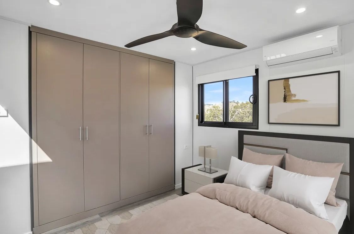 Bedroom with large wardrobe, bed, nightstand, and window with view.