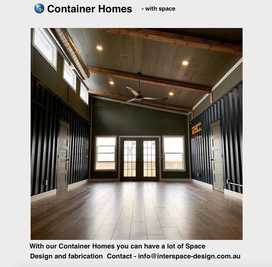 Interior of a container home with wooden beams, dark walls, and a hardwood floor.