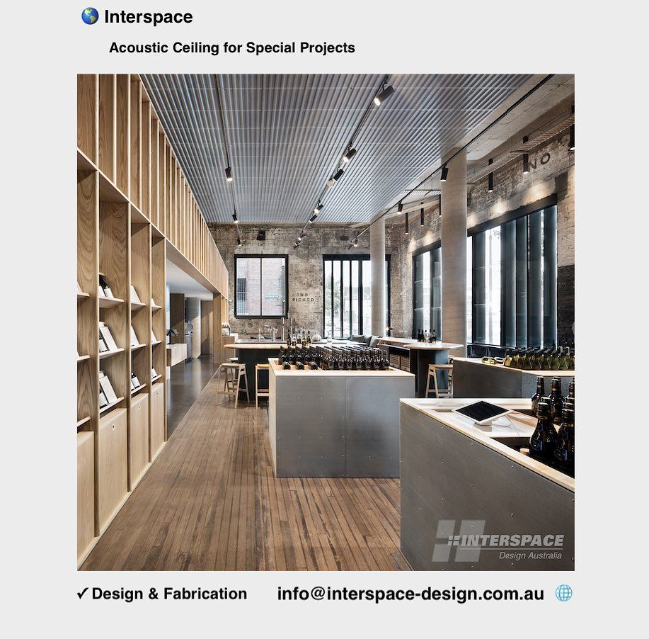 Interior of a shop with an acoustic ceiling, wooden shelving, and counters with items.