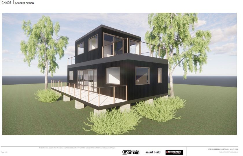 Modern black two-story house with a balcony, windows, and light-colored wooden deck on a grassy lot with trees.