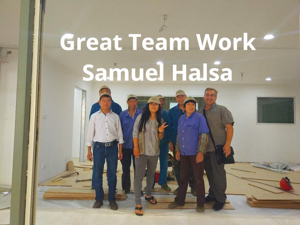 Group of eight people inside a building, smiling, text 